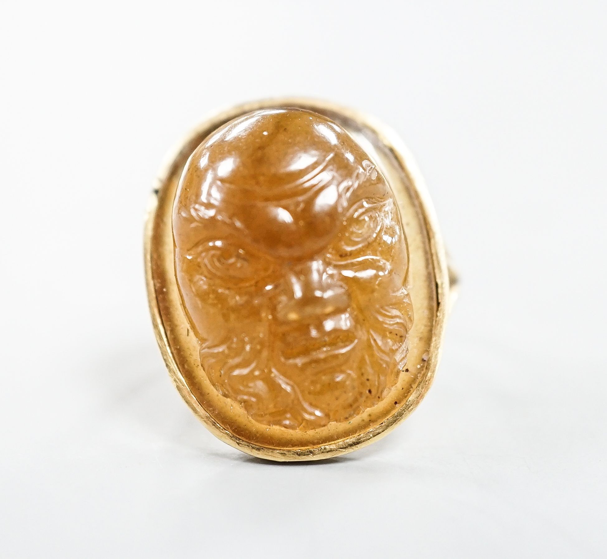 A yellow metal and cabochon brown chalcedony, carved with the face of a gentleman, size K, gross weight 7.3 grams.